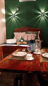 a wooden table with plates and wine glasses on it at Chalé Corina in Pirenópolis