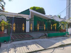 a green gate with yellow decorations on it at Casa Aranza in Cartagena de Indias