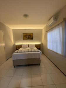 a bedroom with a bed and a window in it at Serra Charm House in Ubajara