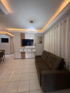 a living room with a couch and a tv at Serra Charm House in Ubajara