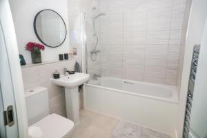 a bathroom with a tub and a sink and a toilet at Little Haven Thames view Free Parking Closer to Heathrow in Staines +40 photos