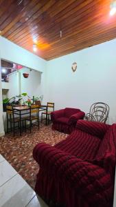 a living room with red couches and a dining table at Hospedaje RIO BLANCO in Iquitos