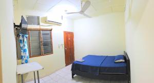 a small room with a bed and a chair at Hospedaje RIO BLANCO in Iquitos