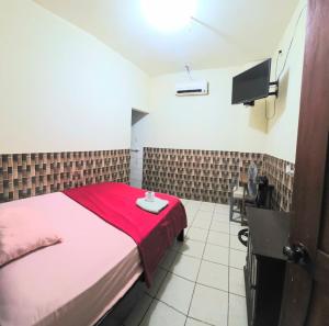 a bedroom with a bed with a red blanket at Hospedaje RIO BLANCO in Iquitos