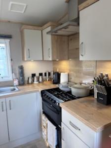 a kitchen with white cabinets and a stove top oven at Honey's Retreat in Hull