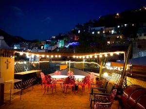 a patio with a table and chairs at night at Hotel Casa Santos Guanajuato in Guanajuato