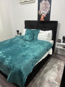 a bedroom with a bed with a green comforter and pillows at Vila Biva in Vrčin +31 photos