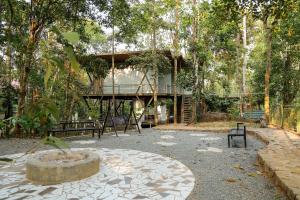 a building in the middle of a park with a tree at ROCKs VILLA RESORT in Meppādi