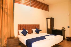 a bedroom with a large bed with blue and white pillows at ROCKs VILLA RESORT in Meppādi +15 photos