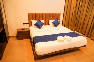 a bedroom with a bed with blue and white pillows at ROCKs VILLA RESORT in Meppādi