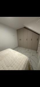 a white room with a bed and white cabinets at Apartamento alhelí 2 in Barbate