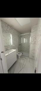 a white bathroom with a sink and a toilet at Apartamento alhelí 2 in Barbate