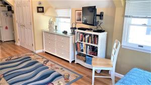 a living room with a tv and a book shelf at Flip Flop Beach in Cape May Point