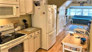 a kitchen with a white refrigerator and a dining room at Flip Flop Beach in Cape May Point +8 photos
