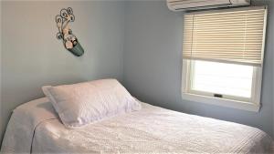 a bedroom with a white bed and a window at Flip Flop Beach in Cape May Point