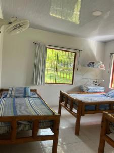 two beds in a room with a window at Finca el milagro Melgar in Melgar