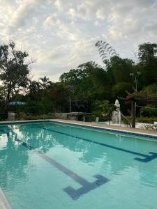 a large blue swimming pool with trees in the background at Finca el milagro Melgar in Melgar +10 photos
