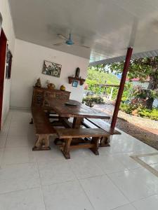a dining room with a wooden table and a bench at Finca el milagro Melgar in Melgar