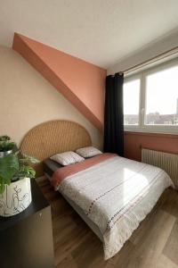 a bedroom with a bed and a large window at HYPER CENTRE - 2 STUDIOS - 2min PLACE KLEBER in Strasbourg