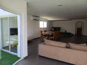 a living room with a couch and a dining room at Villa Dreamy Pool Garden in Eilat