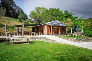 a building with benches and tables in a park at Gibbston Boathouse with Outdoor Bath in Gibbston