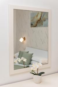 a mirror in a white room with a bed at Port Haven Suite Civitavecchia in Civitavecchia