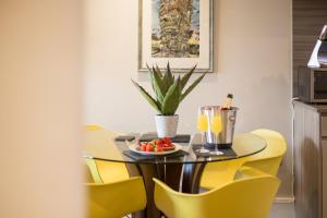 a dining room table with yellow chairs and a plate of fruit at Serenity Inn the City in York