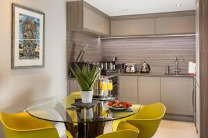 a dining room with a glass table and yellow chairs at Serenity Inn the City in York