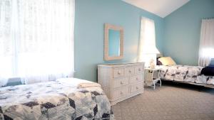 a bedroom with a bed and a dresser and a mirror at Failte in West Cape May