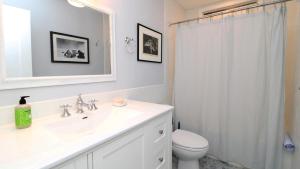 a bathroom with a sink and a toilet and a mirror at Dunescape in West Cape May +28 photos