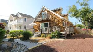 a log house with a porch and a balcony at Dunescape in West Cape May