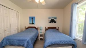 two beds in a bedroom with blue sheets at 149 Emerald Avenue in West Cape May
