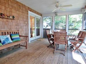 a screened in porch with a table and chairs at Cedar Cottage in Cape May Point
