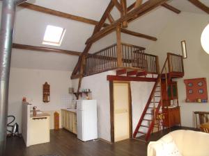 a kitchen with a staircase in a room with a refrigerator at Domaine du Bourg Gites in Gannay-sur-Loire