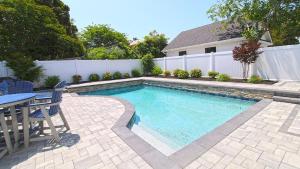 a swimming pool in a backyard with a table and chairs at 1036 Maryland Ave in Cape May