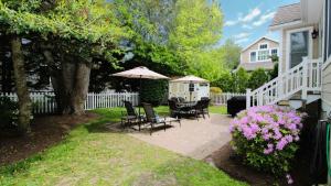 a patio with chairs and an umbrella next to a house at 320 Knox Avenue, Cape May Point in Cape May Point