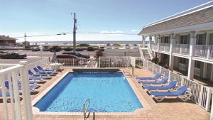 a swimming pool with lounge chairs and a building at Broadway Beach Getaway Unit 2 in Cape May