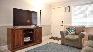 a living room with a flat screen tv on a entertainment center at Broadway Beach Getaway Unit 2 in Cape May