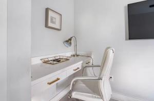 a white chair in a white room with a tv at Villa De Briley - Luxury Creator Station - Fire Pit in Houston