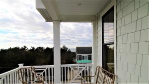 a porch with two chairs and a view of a house at 12 Pearls in Cape May Point