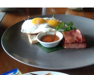 a plate of food with eggs and meat and sauce at Sea Cliff Eco Nusa Penida in Polilit