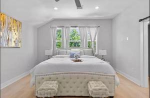 a white bedroom with a large bed and a window at Villa De Briley - Luxury Creator Station - Fire Pit in Houston