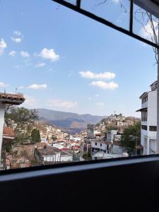 a view of a city from a window at Casa Paloma Querida in Taxco de Alarcón +3 photos