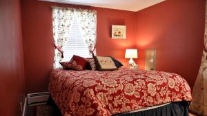 a bedroom with a bed with red walls and a window at 409 Princeton in Cape May Point