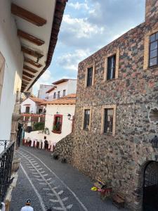 an alley with a stone building and a man standing next to it at Casa Paloma Querida in Taxco de Alarcón