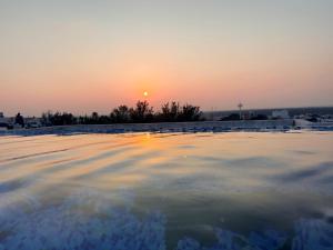 a sunset over an ice rink with the sun setting in the background at Hermoso Departamento Moderno con alberca in Boca del Río