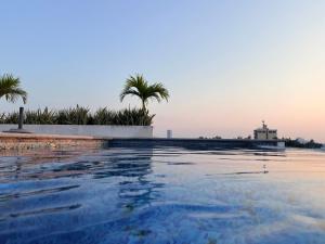 a swimming pool with palm trees in the background at Hermoso Departamento Moderno con alberca in Boca del Río