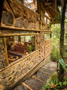 a stone building with a stone wall with cushions on it at Bosque Hondo Ecoliving in Medellín