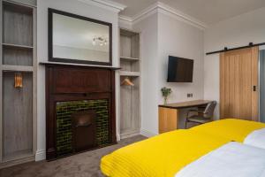 a bedroom with a yellow bed and a fireplace at Elephant and Castle in Wakefield