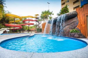 a water slide in a pool with a waterfall at Flat in Caldas Novas in Caldas Novas